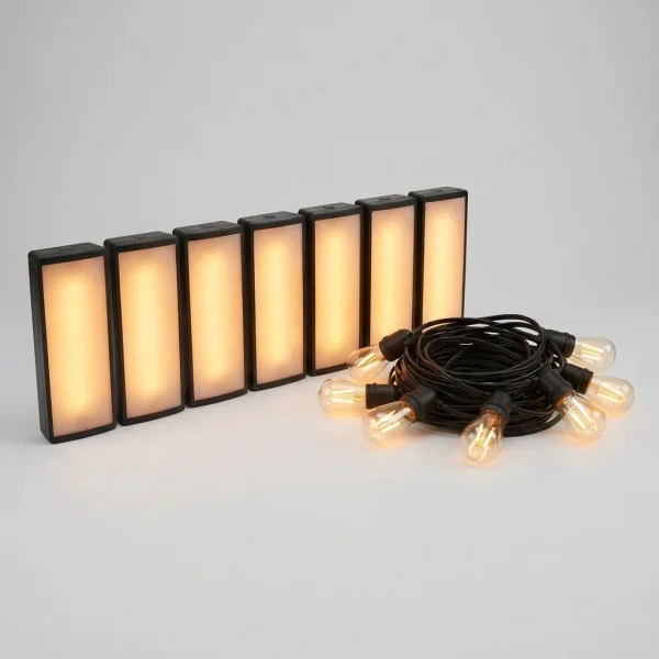 Sete uplights LED acesos em tom âmbar ao lado de um cordão de luzes festoon enrolado
